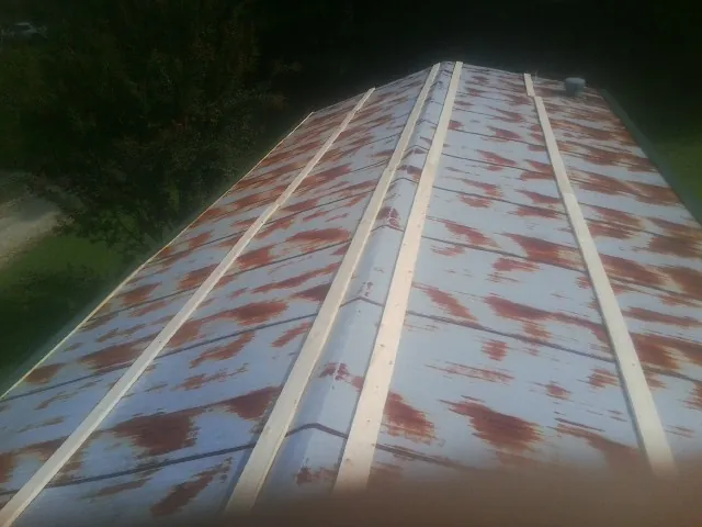 Rusted metal roof panels with new wood purlins before replacement — Storm Damage Roof Repair in Jamesville by Roofing Brothers